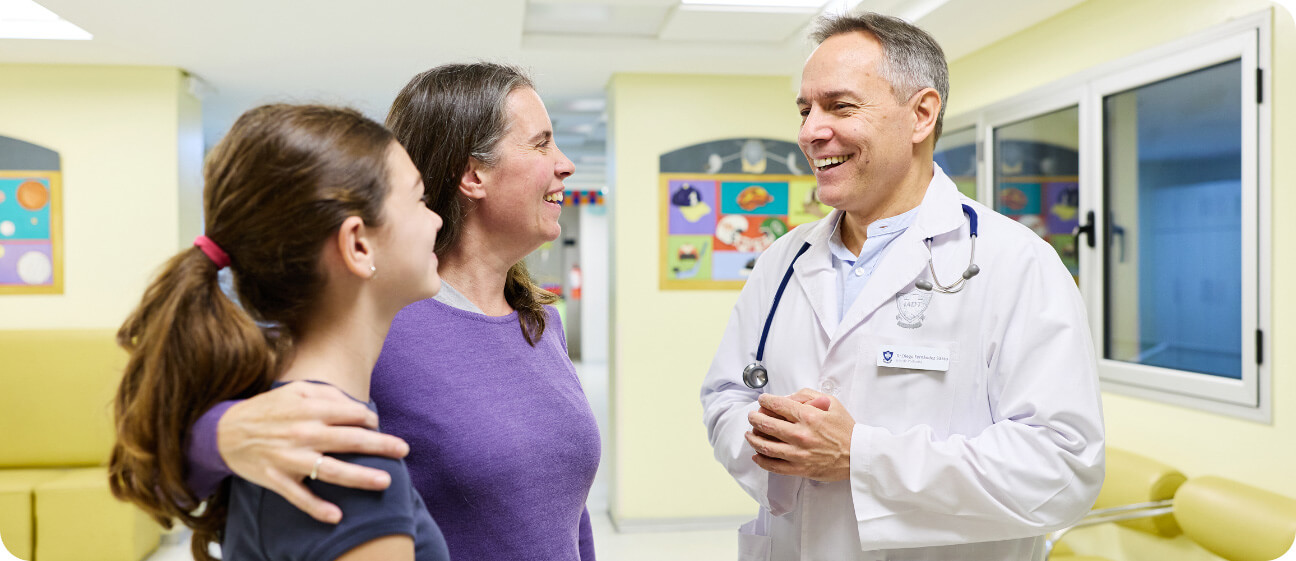 Médico pediatra conversando con una paciente y su madre en el área de consultorios externos de Pediatría del IADT